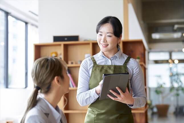 カフェで注文を取る女性店員